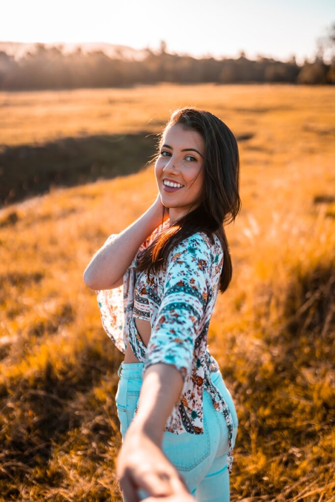 girl in blue and white floral dress standing on brown grass field during daytime